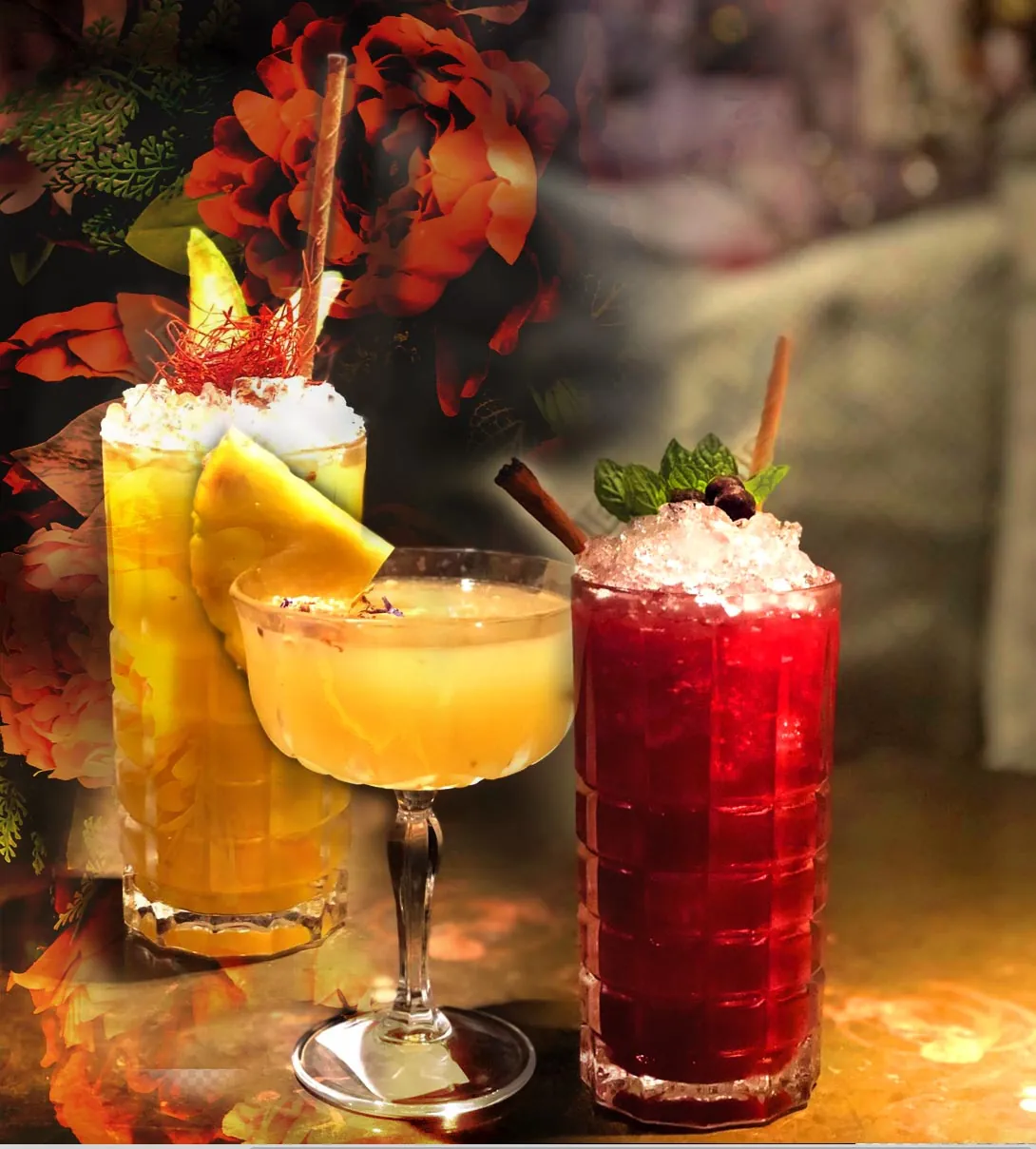 Three colourful signature cocktails with fresh fruit and floral garnishes