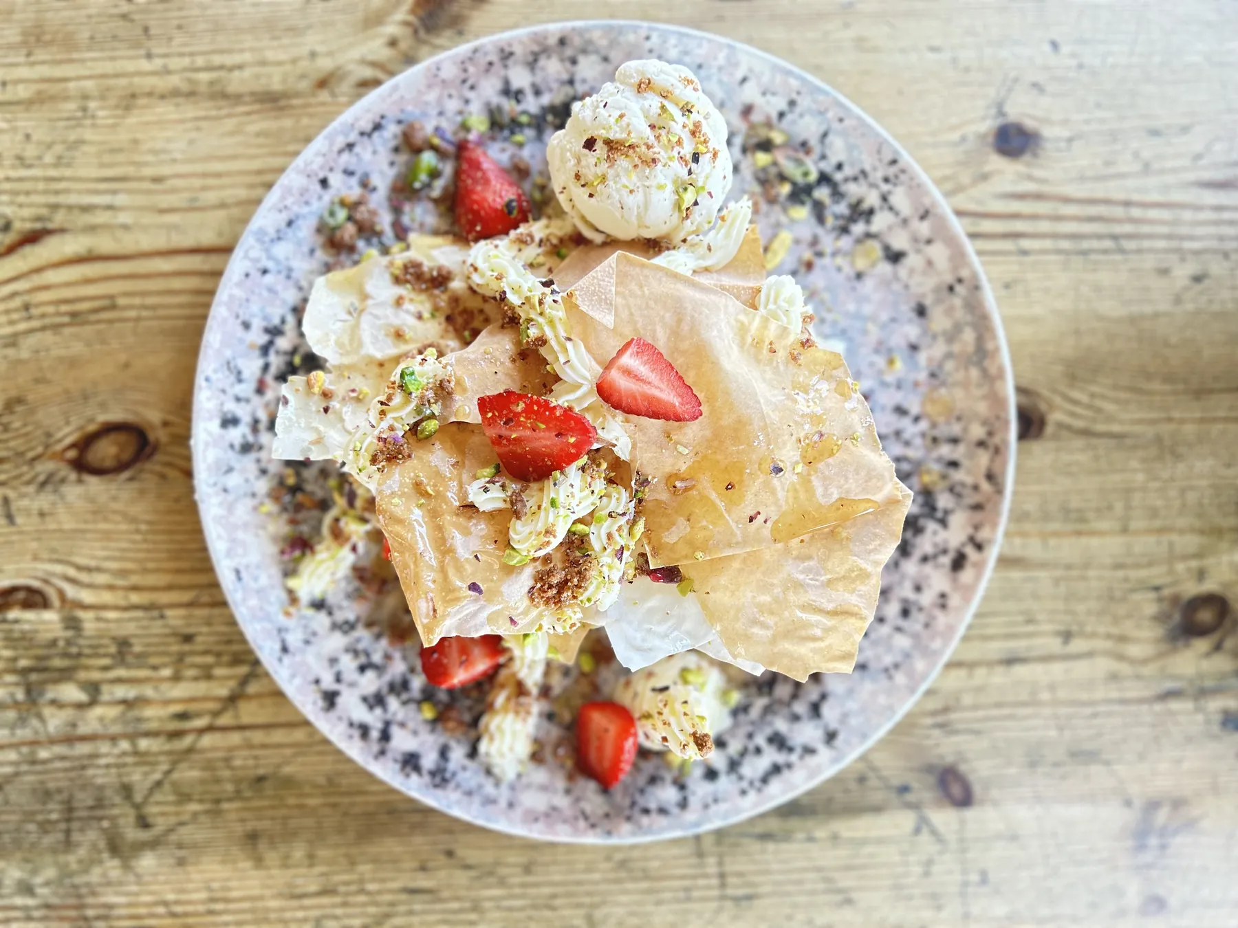 Crisp layered pastry with strawberries, cream and pistachios